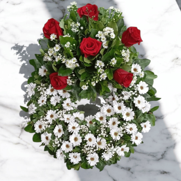 Corona floral redonda con pucho de rosas rojas