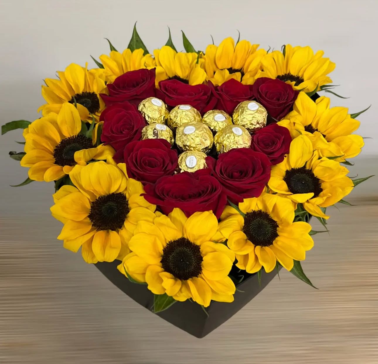 Caja de rosas y girasoles y chocolates